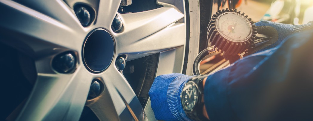 Mechanic Using Tire Pressure Gauge